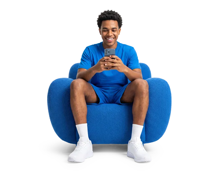 Cliente sorrindo em poltrona azul usando o celular conectado